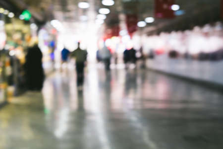 Bright defocused blurred background with unrecognizable people at the airport. Abstract image of crowd of people in public placeの写真素材