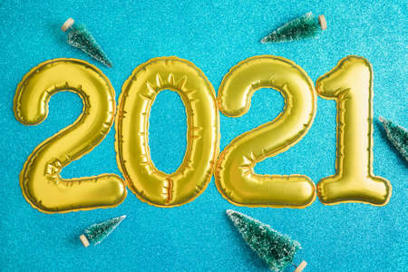 Christmas festive background with golden numbers 2021, toy trees. Abstract glitter blurred background shiny blue ai aqua. Bright sparkling wallpaper with bokeh textureの写真素材