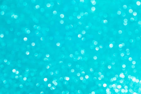 Abstract glitter blurred shiny blue aqua background. Bright sparkling bokeh wallpaper style. Festive Christmas holiday futuristic texture.の写真素材