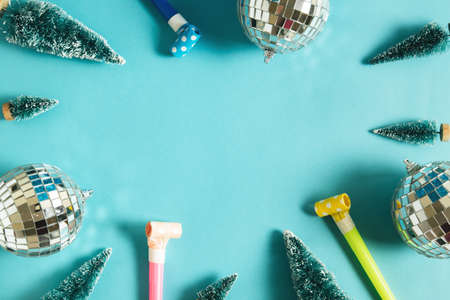 Christmas minimal festive background with disco ball, toy tree, air whistles. Abstract christmas background shiny blue ai aqua. Flat lay. Top view. Copyspace.の写真素材