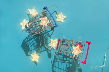 Christmas minimal festive background with star garland in a supermarket basket. Abstract Christmas and New Year color background blue ai aqua. Bright sparkling wallpaper. Flat lay. Top view.の写真素材