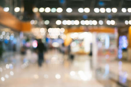 Bright defocused blurred background with unrecognizable people at the airport. Abstract image of crowd of people in public place.の写真素材