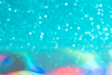 Abstract mixed holographic blue ai aqua blurred glitter shiny background. Liquid neon rainbow foil unicorn style. Bright sparkling bokeh style. Festive Christmas holiday iridescent futuristic texture.の写真素材