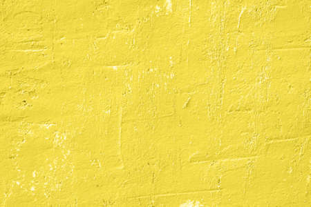Concrete yellow colorful wall surface texture. Abstract grunge bright illuminating color background with aging effect. Copyspace.の写真素材