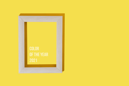 Frame for photo or painting on bright illuminating yellow background. Mockup. Place to insert text, images. Top view. Flat lay. Color of the year 2021.の写真素材