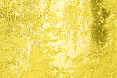 Concrete yellow colorful wall surface texture. Abstract grunge bright illuminating color background with aging effect. Copyspace.の写真素材