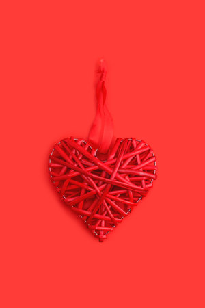 Red wicker heart symbol lies on the background to Valentines Day. Top view. Flat lay. Greeting card, concept of the holiday of lovers.の写真素材