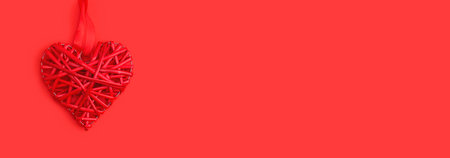 Red wicker heart symbol lies on the background to Valentines Day. Top view. Flat lay. Greeting card, concept of the holiday of lovers. Banner.の写真素材