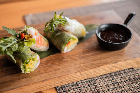 Spring rolls with shrimp, wooden chopsticks and soy sauce. Asian cuisine.の写真素材