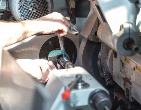 Checking size and quality is made on the machine parts with a micrometerの写真素材