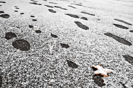 Footprints on a snowy path on a cold fall dayの写真素材