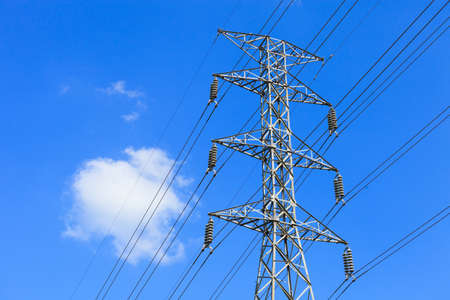 Electricity pylon against blue cloudy sky