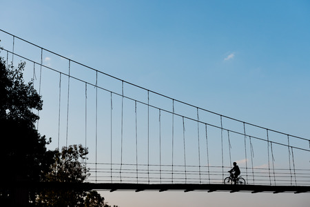 Bike silhouette on Rope bridgeの写真素材