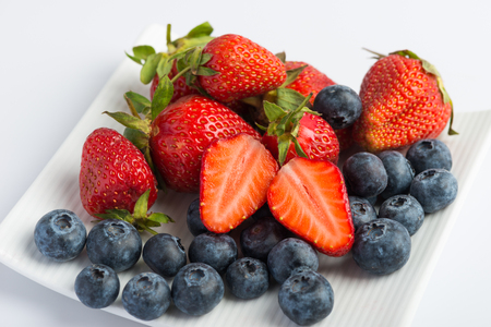 Fresh strawberries and blueberries on white backgroundの写真素材