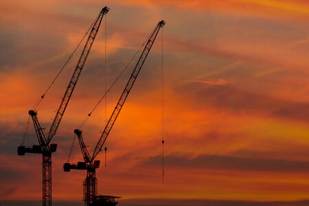 sunset and silhouette of the crane operatingの写真素材
