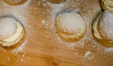 The traditional shrovetide bun - semla on a cutting board with dusted sugar.の写真素材