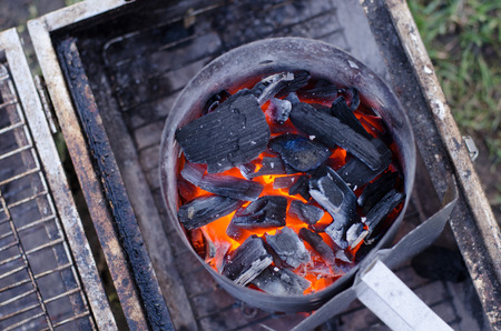 A chimney starter in use to get the charcoal ready for the grill in a more environmentally friendly way.の写真素材