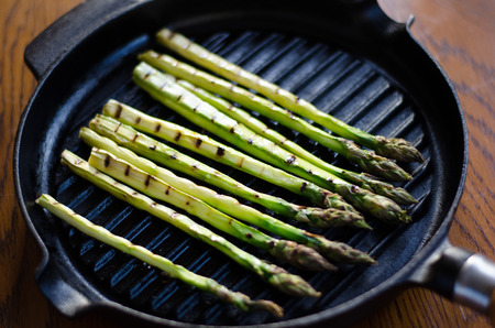Grilled green asparagus on a cast iron grillpanの写真素材