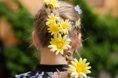 Girl with flowers in her hair during a day in town.の写真素材