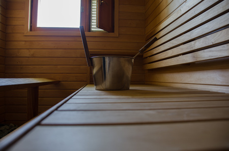 Sauna with a window and a bucket for water to throw on the hot stones.
