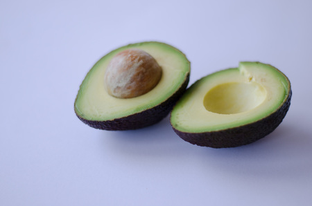 An halved Hass avocado on white background