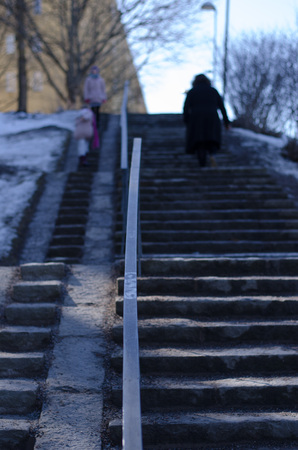Family out for a walk on top of a set of stairs on a sunny day in urban scenery.の写真素材