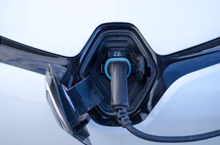 Stockholm, Sweden - 14 May 2019. The electric car, Renault Zoe in a parking lot recharging it's battery on a wet day.のeditorial素材