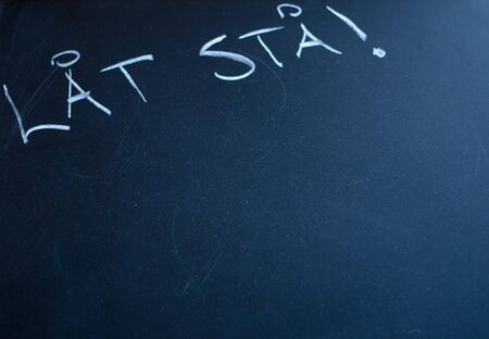 A black chalkboard with swedish words written on it.