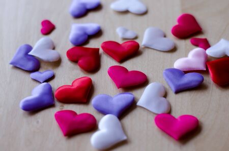 Hearts in different colors and sizes on wooden tableの写真素材