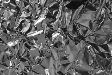 Shiny silver foil texture background, pattern of wrapping paper with crumpled and wavy.の写真素材