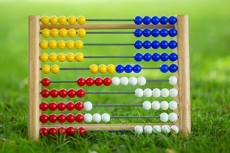 Old Abacus on gras. Learn to count with coloured pearlsの写真素材