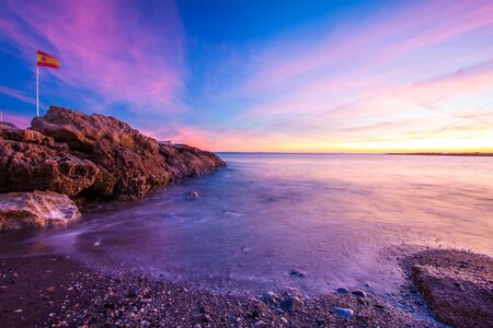 beautiful colorful sunset at rocky beach in spainの写真素材
