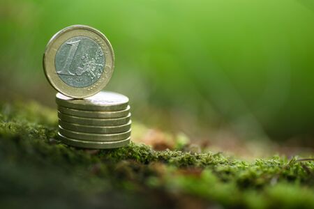 One Euro Coin on pile of coins in Nature - Green Moneyの写真素材