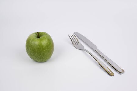 Green apple with a fork and knife.の写真素材