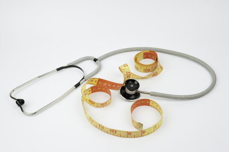 Stethoscope and tailoring meter on white background .の写真素材