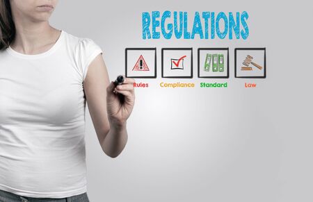 Beautiful woman writing - Regulations, business concept. Light gray background