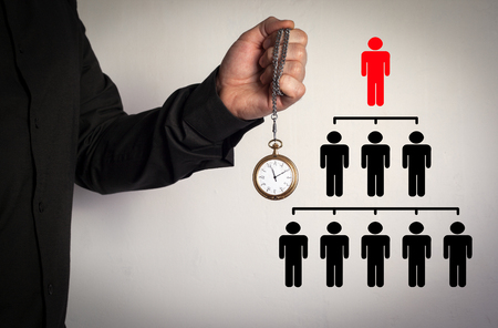 People pyramid with one leader at the top and silhouettes at all levels, business concept. Red Arrow and Icons Around. Man holding chain clock on white backgroundの写真素材