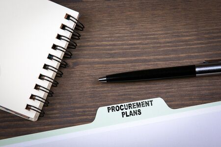 Procurement Plans Concept.  Folder Register on a dark wooden desk.の写真素材