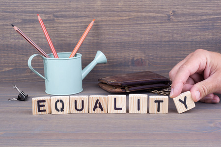 Equality concept.Wooden letters on dark background. Office deskの写真素材