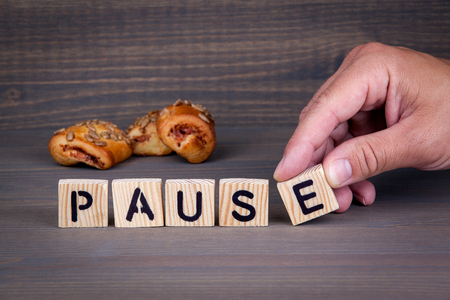 pause. Wooden letters on dark background. Office deskの写真素材