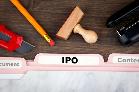 IPO Initial Public Offering. Folder Register on a dark wooden desk.の写真素材