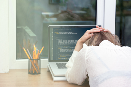 woman freelance programmer working from home. website code on screen.
