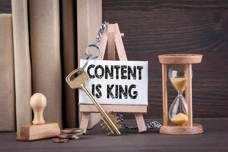 content is king concept. Sandglass, hourglass or egg timer on wooden table showing the last second or last minute or time outの写真素材