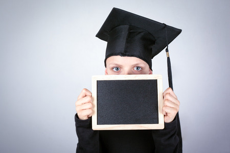Boy with a Chalkboard in hands. Knowledge, education and a successful career background.の写真素材