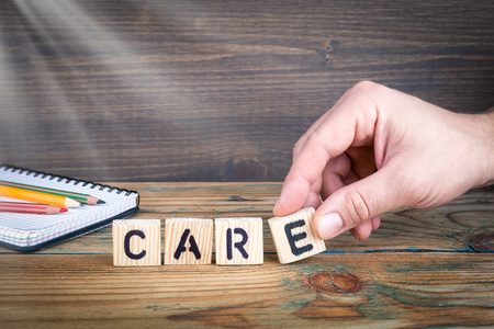 care. Wooden letters on the office desk, informative and communication background.の写真素材
