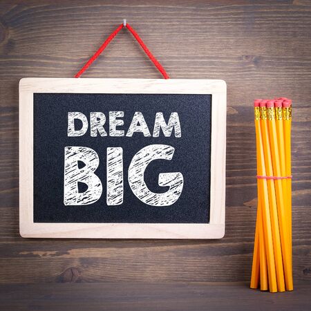 dream big concept. Chalkboard on a wooden background.