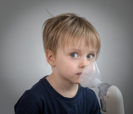 Little boy takeing inhalation for respiratory didease.の写真素材