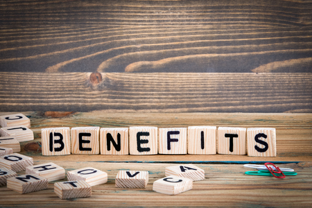 Benefits. Wooden letters on the office desk, informative and communication background.の写真素材
