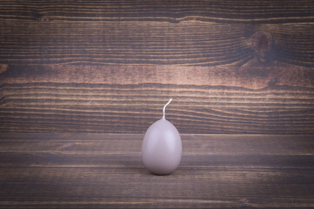 Candle in the form of Easter egg. Abstract holiday and spring background.の写真素材
