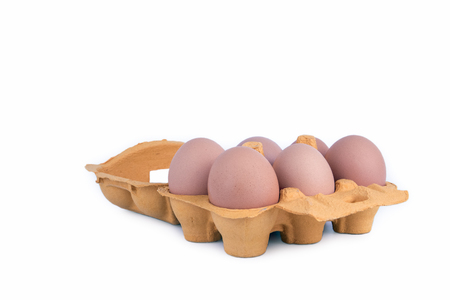Close-up view of raw chicken eggs in box on white background.
